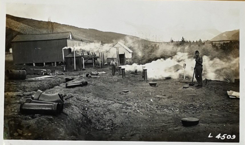 Man with brush next to smoking chimneys