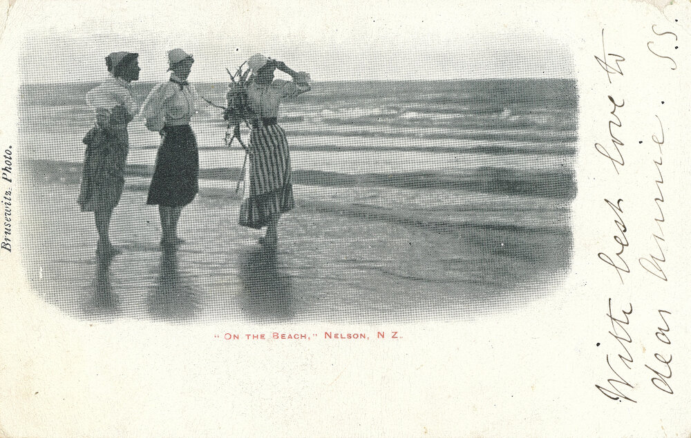 Three women pose for a photo at Tāhunanui Beach