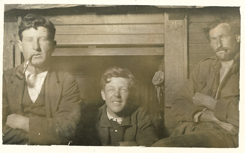 Three men in front of fire surround