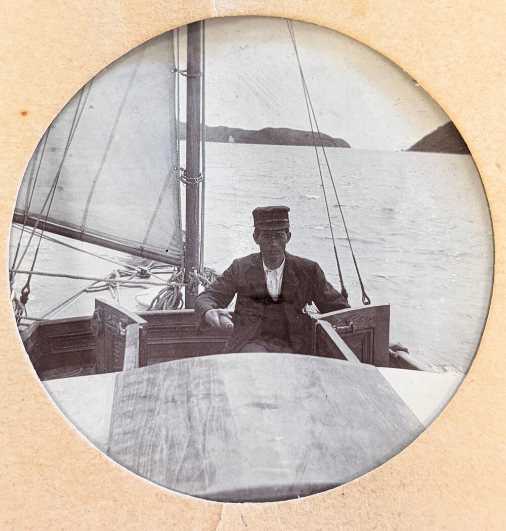 Man with glasses at the tiller