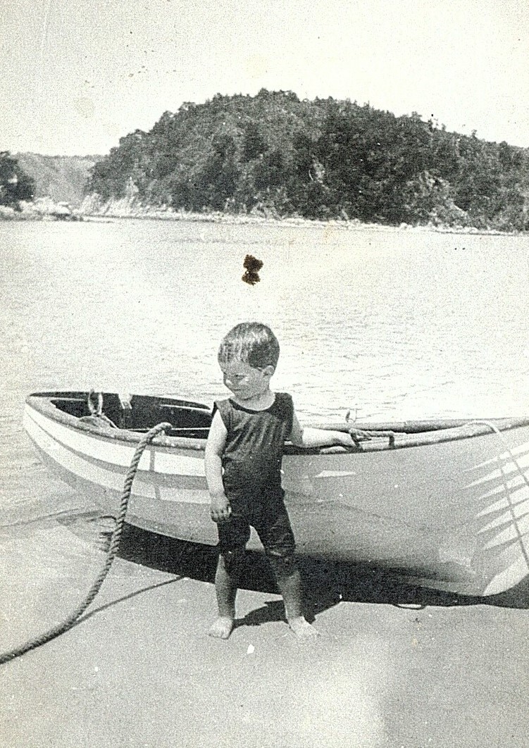 Small child in front of boat