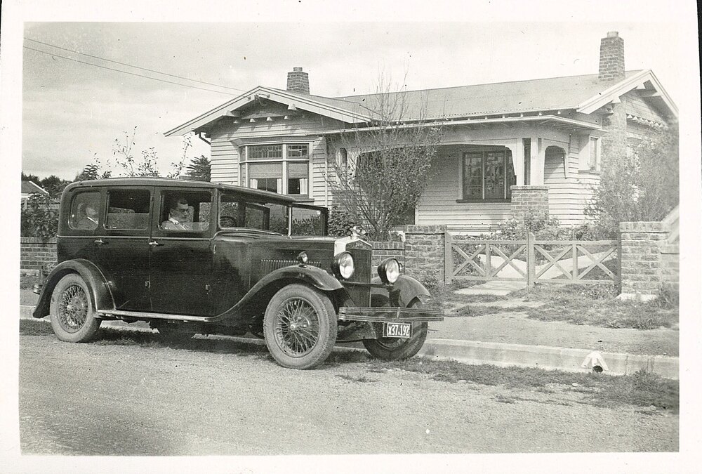 Motorcar in front of house