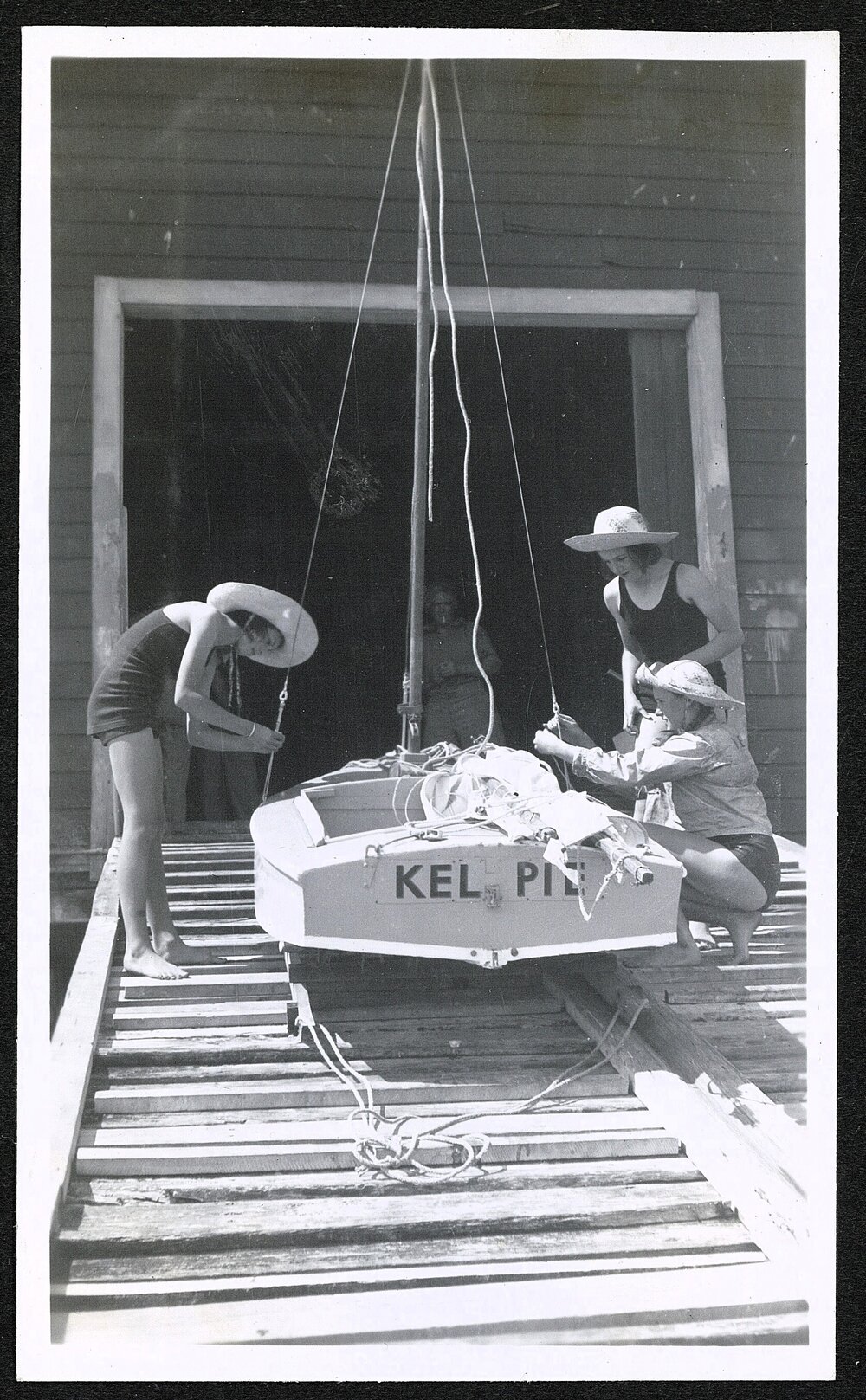 Three young women prepare Kelpie for launching