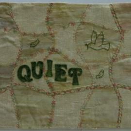 Patchwork effect quilt piece embroidered with a dove and the word quiet