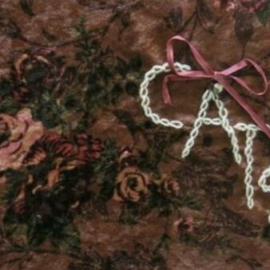 Rose fabric with a ribbon bow and chain stitched with the word cats