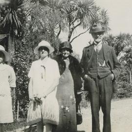 Four people standing in a garden, 1930s