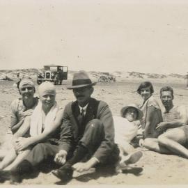 Four women and two men sitting on a Foxton beach, 1929