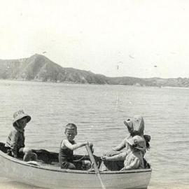 Child rowing a dinghy with adult and child