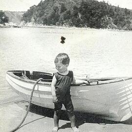 Small child in front of boat