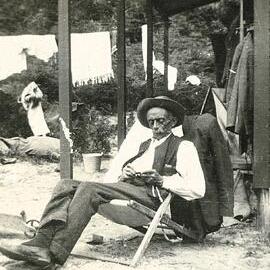 Elderly man sitting on deck chair at the bach
