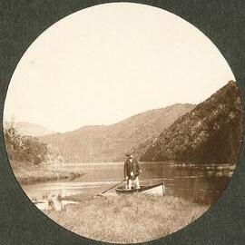 Man standing up in a rowboat
