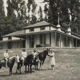 Children with horses and house on a hill